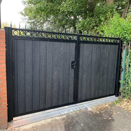 Square black driveway gates with grey wood-effect infill and circular detailing.