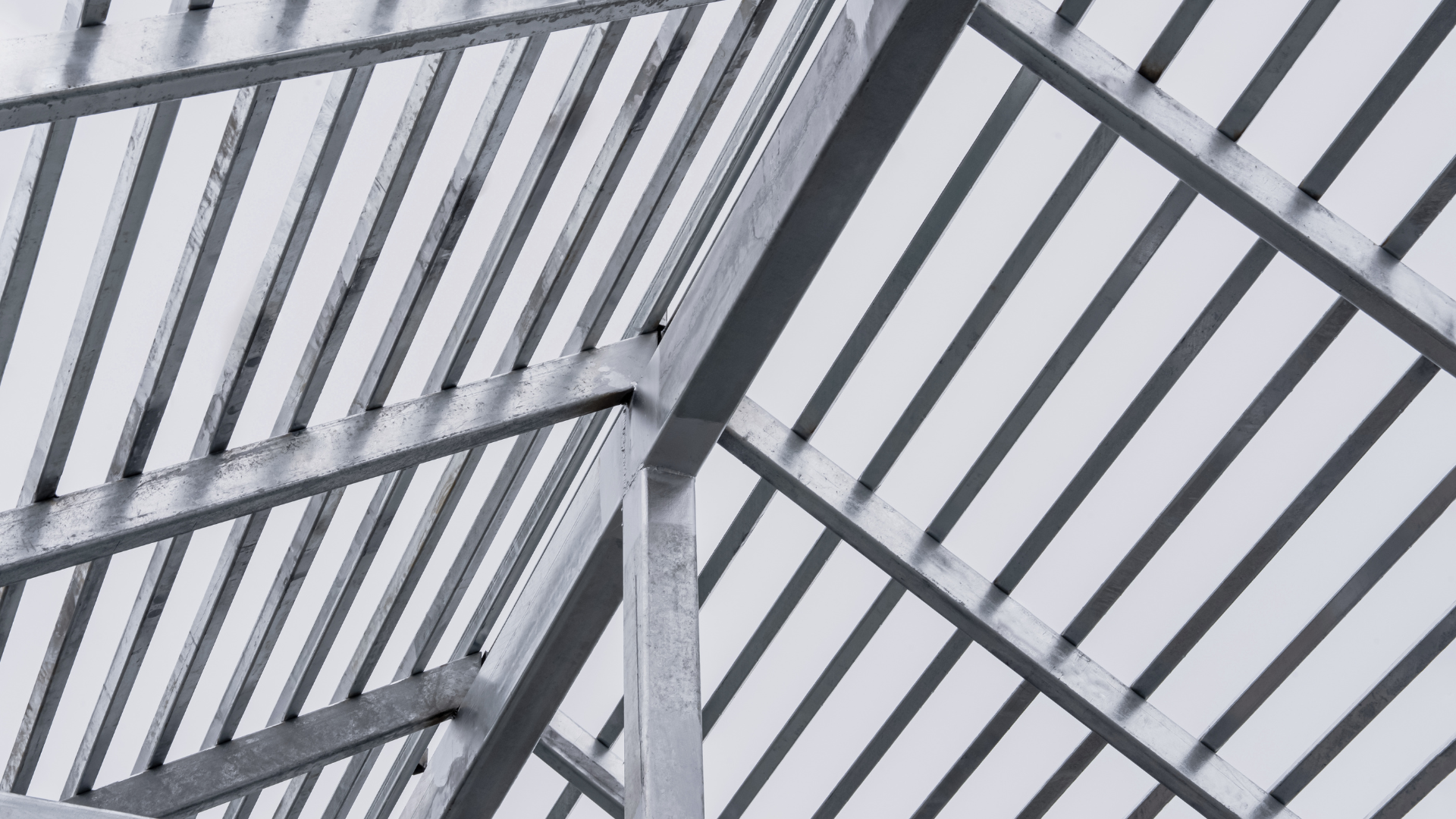 Galvanised structural steel roof purlins and rafters close-up.